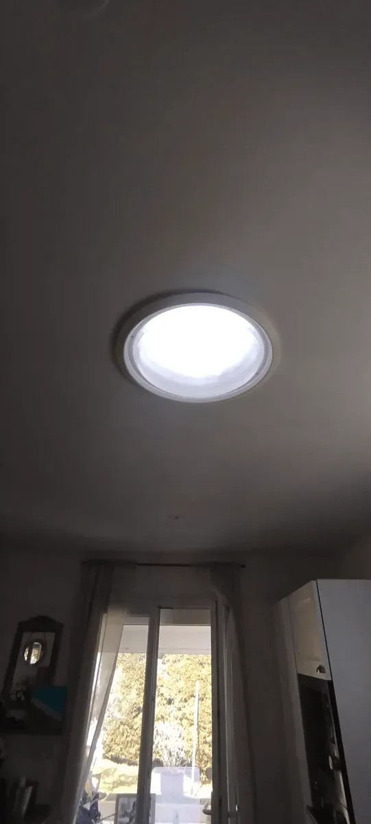 Puits de lumière diffusant la lumière naturelle au plafond d'une pièce de vie, réalisation JID Rénov